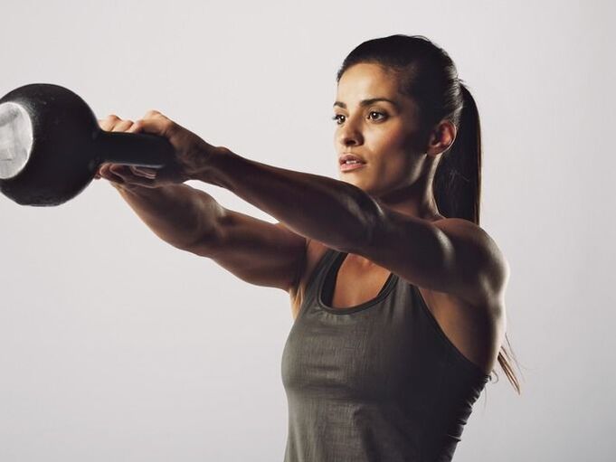 Dievča vykonáva cvičenie na zväčšenie pŕs pomocou kettlebellu